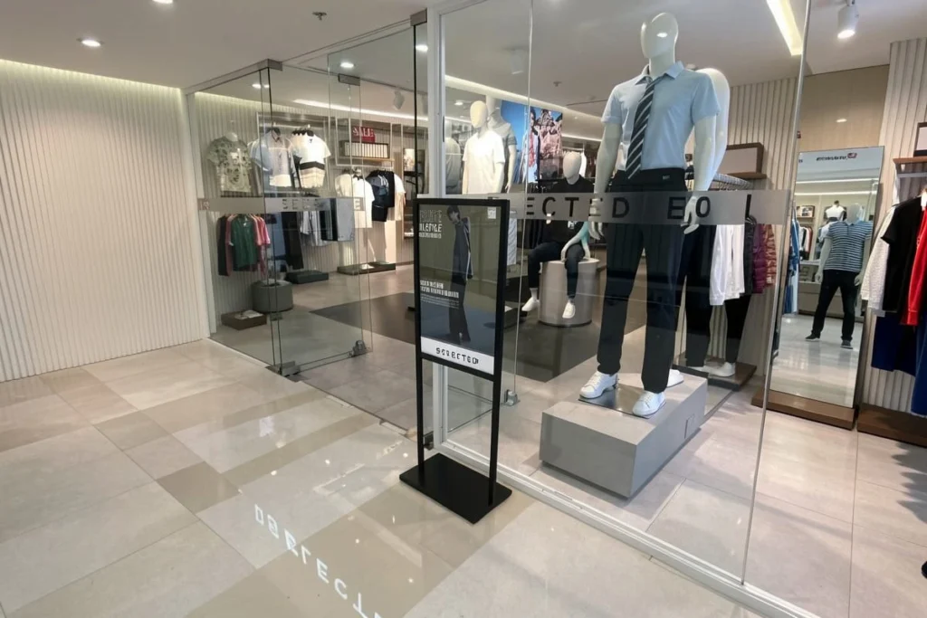 un support d'affichage sur pied devant un magasin de vêtements